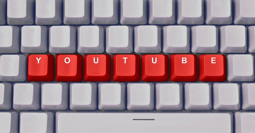 A White keyboard. In the keyboard button is written with the word youtube in red color. Each letter in each button. 