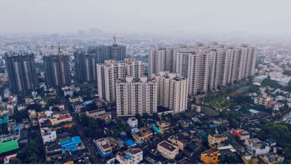 A drone view of the place in India where large buildings are present also there is small house and market are present. learn how to start a business in India by understanding the India market.